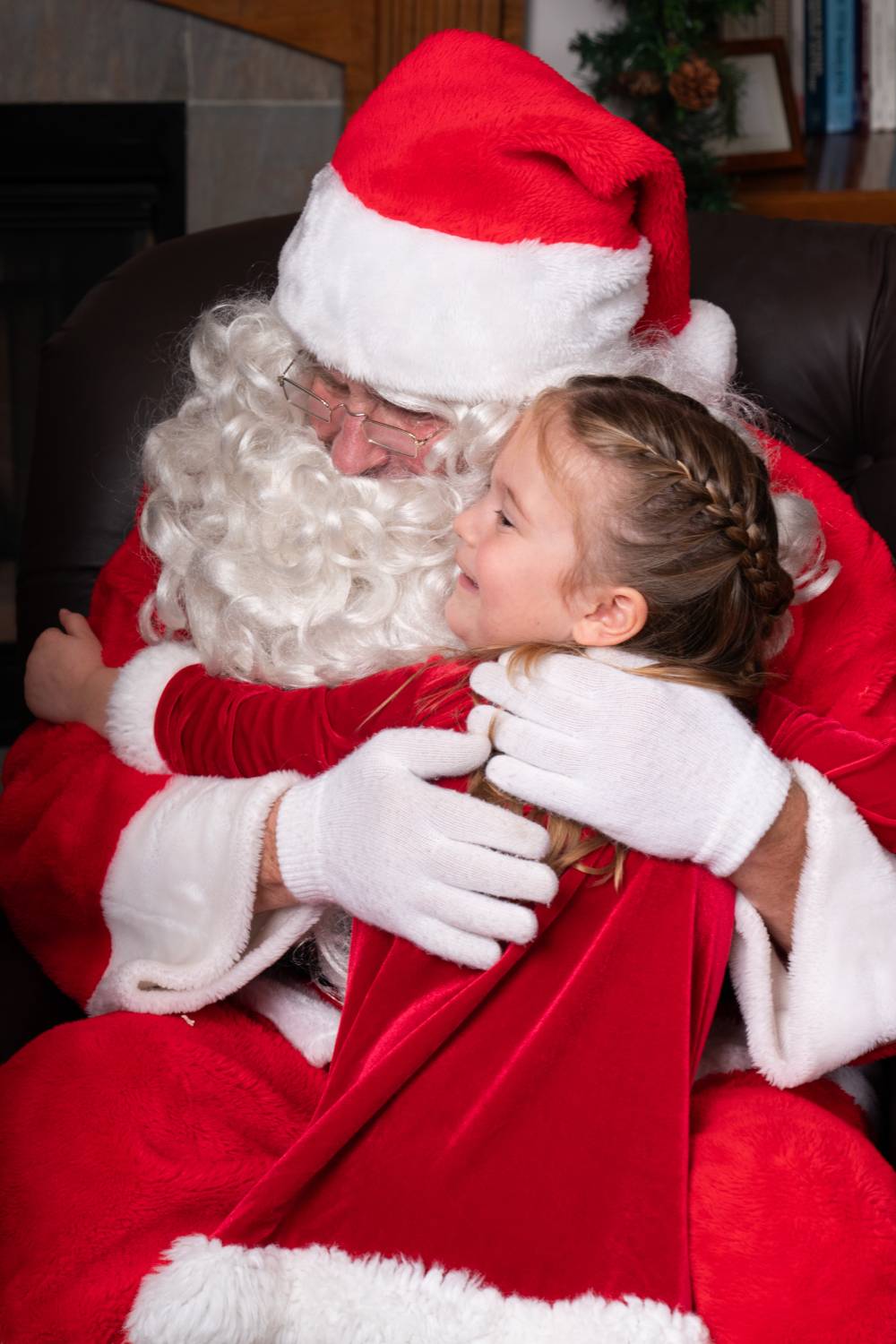 A little girl hugging Santa.